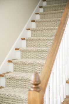 an image of a stair case with carpet on the bottom and handrails down