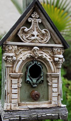 a bird house with a water fountain in the center