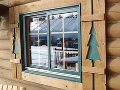 there is a wooden cabin with a window and trees on the side of the house