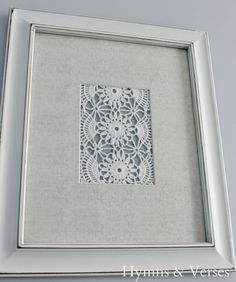 a white frame with an intricate lace doily