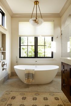 a large white bath tub sitting under a window