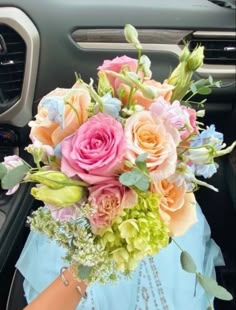 a bouquet of flowers is sitting in the passenger seat of a car, ready to be picked up