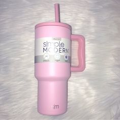 a pink tumbler cup sitting on top of a white blanket