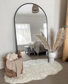 a room with a large mirror and some plants in the corner on the carpeted floor