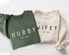 two sweatshirts with the word hubby printed on them are laying next to each other