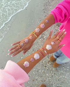 two girls are holding their hands with seashells painted on the arms and wrists