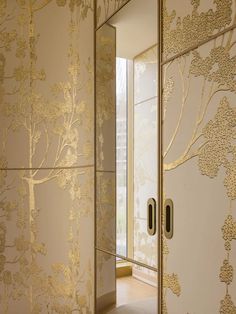 an open door leading into a room with gold wallpaper