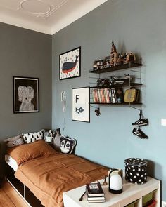 a bed sitting in a bedroom next to a shelf filled with books and other items