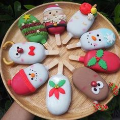 a wooden plate topped with lots of decorated cookies