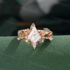 an engagement ring with a princess cut diamond in the center and leaves on each side