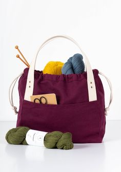 a bag with yarn and knitting needles in it