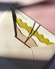 an origami envelope with a piece of yellow paper sticking out of the inside