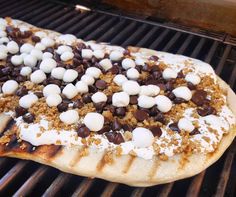 an uncooked pizza with marshmallows and chocolate chips on the grill