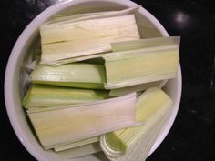 a bowl filled with cut up celery on top of a black countertop