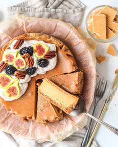 a pie with fruit and whipped cream is on a plate next to some silverware