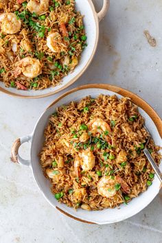 two bowls filled with shrimp and rice on top of a white counter next to each other