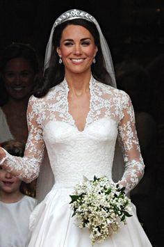 the bride and groom hold hands as they walk down the aisle