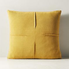 a yellow pillow sitting on top of a white table