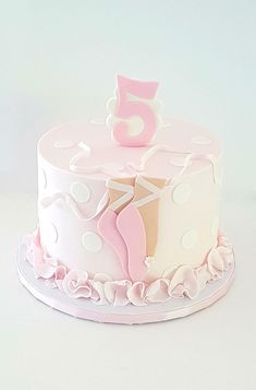 a pink and white birthday cake with a number 5 on it's bottom tier