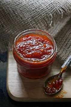 a wooden cutting board topped with a jar of jam