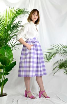 Lilac and white check high waist full gathered skirt. Perfect for casual outfits and special ocasions with pair of trainters or high heels. 100% cotton.  Elastic at the back of waist.  Two side pockets. Midi lenght about 70cm + 5 cm waistband. Handmade in UK.  Model wears size S.  HOW TO CHOOSE A SIZE ?   Using a measuring tape, measure the smallest part of your waist.  SIZE CHART: (CM) XS - W: 66 CM S - W: 70 CM M - W: 74 CM  L - W: 78 CM  XL - W: 82 CM  CARE INSTRUCTIONS: Hand wash only, do no Cheap Gingham Skirt For Spring, Spring Plaid Skirted Bottoms, Plaid Skirted Bottoms For Spring, Gingham Skirt For Summer Picnic, Spring Gingham Pleated Skirt, Summer Gingham Skirt For Picnic, Plaid Cotton Lined Skirt Bottoms, Plaid Cotton Skirted Bottoms, Summer Plaid Pleated Skirt