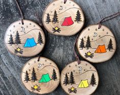 four wooden ornaments with camping designs on them