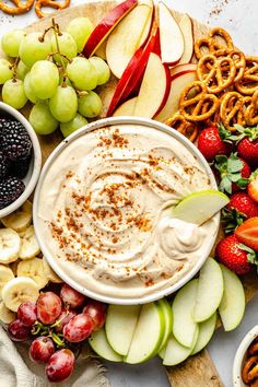 a platter with fruit, pretzels and dip