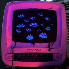 an old tv with blue eyes on it is lit up in pink and purple light