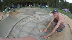 a man squatting down in front of a skateboard ramp