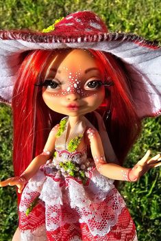 a doll with red hair wearing a white dress and large hat on top of it's head