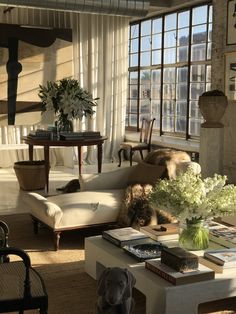 a living room filled with lots of furniture and flowers on top of a coffee table