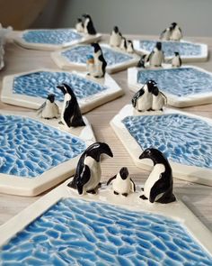 several penguins are sitting in the middle of an ice floet with blue and white designs