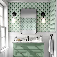 a bathroom with green and white wallpaper, two sinks and a large mirror on the wall