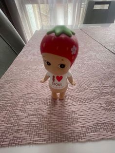 a small toy strawberry sitting on top of a table