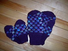 two purple mittens sitting on top of a wooden floor