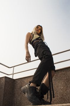 a woman is walking up some stairs with her hand on her hip and looking at the camera