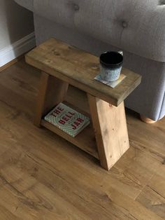 a small wooden table with a book on it in front of a couch and chair