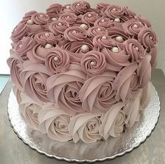 there is a large cake with pink frosting roses on it