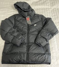 Nike Windrunner PrimaLoft Storm-Fit Puffer Jacket  Size: Men's XXL Color: Black DR9605-010 MSRP: $200 Measurements: Chest (armpit to armpit) - 27 inches Length (top to bottom) - 30 inches Rock the iconic look of the Windrunner while you brave the cold in this toasty hooded jacket. It takes the classic puffer look and backs it up with the insulating power of PrimaLoft® Thermoplume insulation. Nike Storm-FIT technology resists elements like wind and water to help keep you comfortable in harsh weather conditions. A relaxed fit gives you some room to layer up underneath for those extra chilly days. More Benefits Style: Standard-fit Windrunner puffer jacket Materials: Water-repellent and windproof woven fabric Construction: Superwarm PrimaLoft insulation with smooth taffeta lining Storage: Zipp Nike Windrunner, Puffer Jacket Men, Fabric Construction, Weather Conditions, Puffer Jacket, Large Black, Water Repellent, Hooded Jacket, Woven Fabric