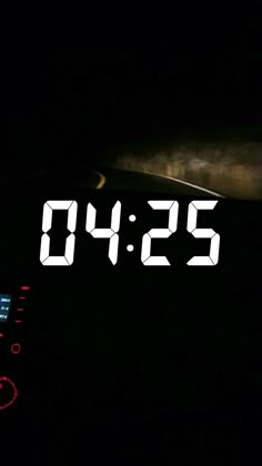 the digital clock is displaying the time in the car's dash light at night