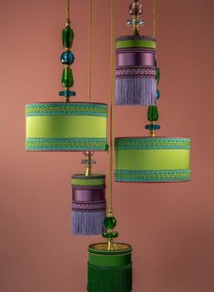 three colorful lamps hanging from the ceiling with tassels and beads on each lamp