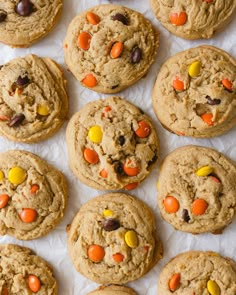 chocolate chip cookies with candy corn and m & m's in the middle, on top of parchment paper