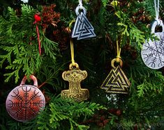 four ornaments are hanging from a christmas tree