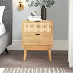 a bedroom with a bed, nightstand and plant on the side table in front of it