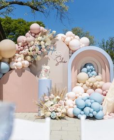 an outdoor area with balloons and flowers on the ground