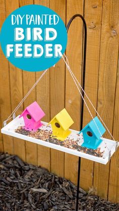 a bird feeder with three different colored birds on it and the words diy painted bird feeder