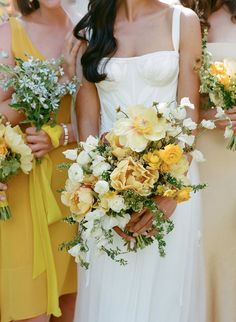 bridesmaids holding bouquets of yellow and white flowers