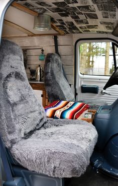 the interior of an old truck with fur and pillows on it's seat covers