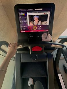 a person on a treadmill with the screen showing an image of a woman's face