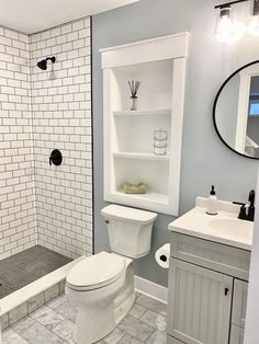 a white toilet sitting inside of a bathroom next to a walk in shower and sink